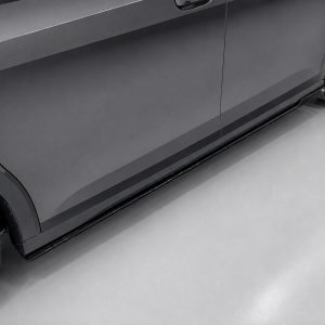 Close-up of a dark gray car’s side, showing the rocker panel and a wheel with alloy rim