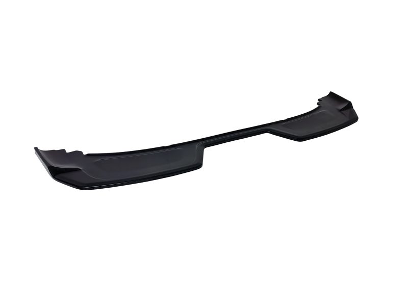 Long black plastic front bumper lip spoiler laid on a white background for a car’s aerodynamics