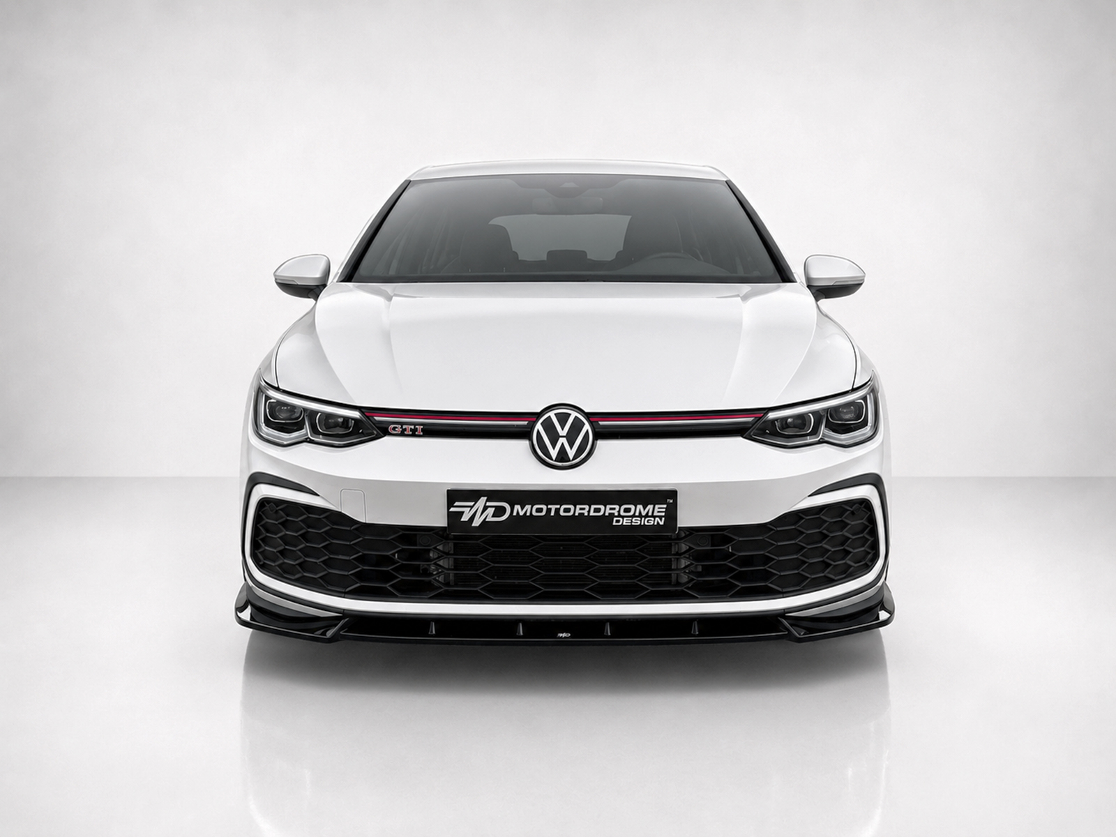 K192-001_1jpg - OPSHOLDERS Front view of a white Volkswagen GTI with a black honeycomb grille, red accent stripe, and a center VW emblem; a MD MotorDrome Design plate is mounted on the bumper.