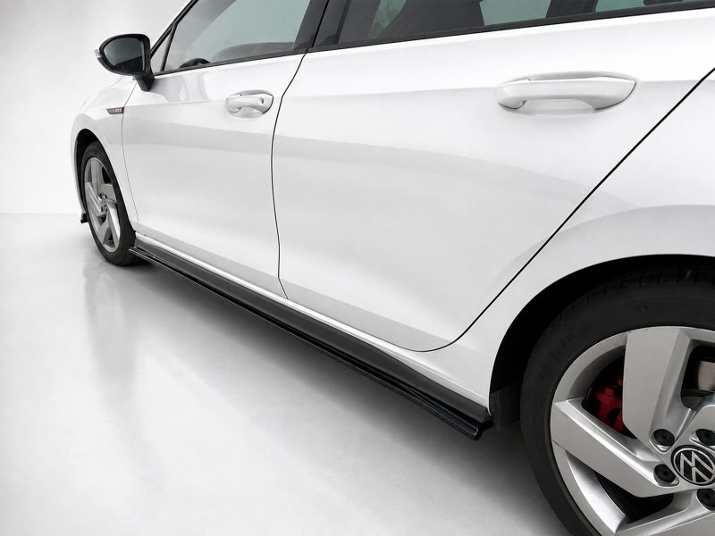 K192-002_3jpg - OPSHOLDERS Close-up of a white car side, showing door, mirror, and alloy wheel with a red brake caliper visible behind it