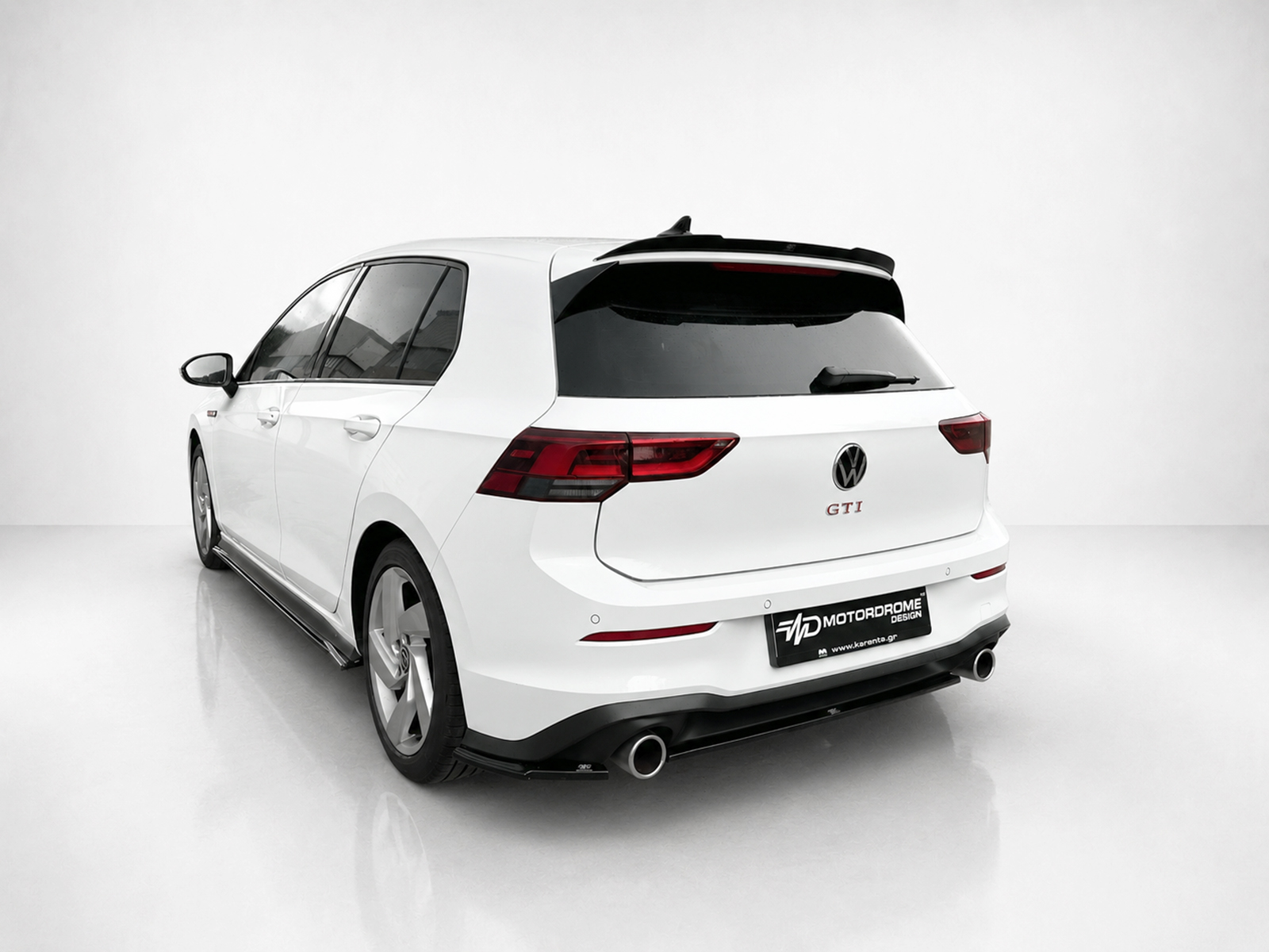 K192-003_1jpg - OPSHOLDERS White Volkswagen GTI wagon shown from the rear three-quarter view, featuring a sport rear bumper and dual exhausts, in a clean studio setting.
