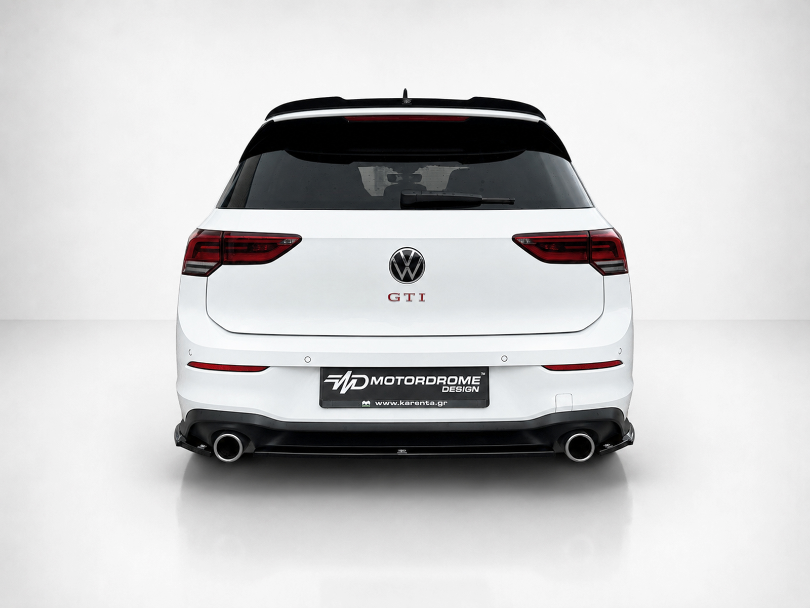 K192-004_1jpg - OPSHOLDERS Rear view of a white VW GTI hatchback with dark taillights and a custom Motordrome Design license plate area.