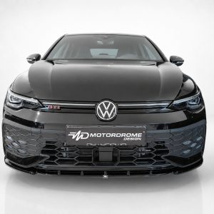 Front view of a glossy black Volkswagen with GTI badge and prominent honeycomb lower grille, centered emblem visible