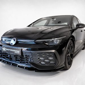 Front three-quarter view of a glossy black Volkswagen with a bold, honeycomb front grille in a studio setting