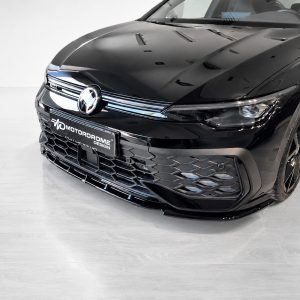 Front of a glossy black car in a showroom, with a chrome grille and a Motordrome Design license plate.