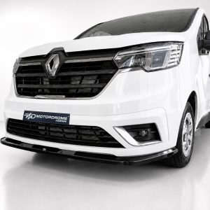 Front view of a white van with a prominent black grille and sleek headlight, in a studio setting, Motordrome Design plate on bumper.