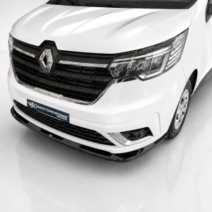 Front three-quarter view of a white Renault van showing the grille, emblem, and headlights in a studio setting, with a Motordrome Design plate on the bumper.