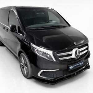 Front-left three-quarter view of a glossy black Mercedes-Benz passenger van in a white studio environment.
