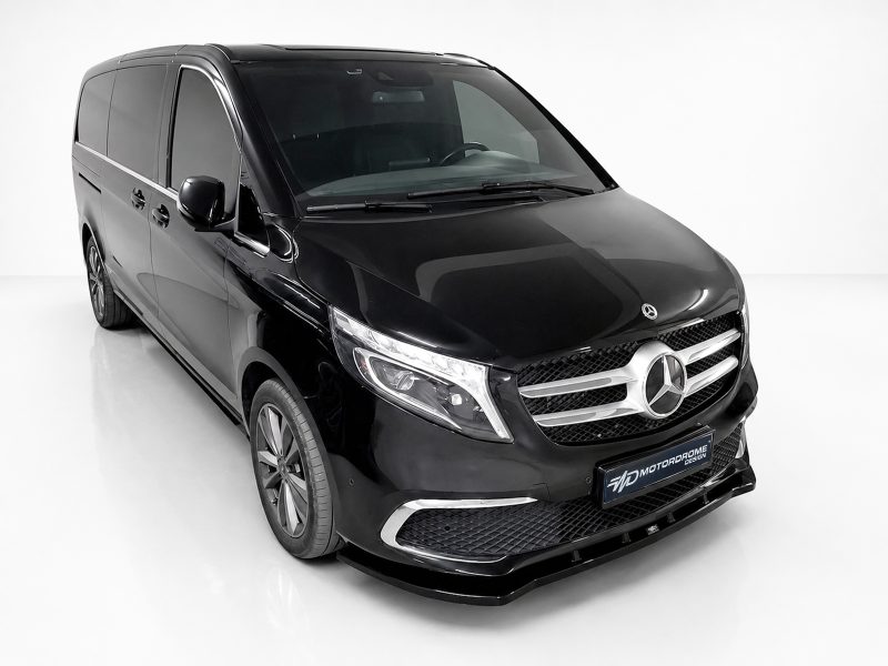 Front-left three-quarter view of a glossy black Mercedes-Benz passenger van in a white studio environment.