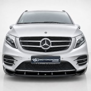 Front view of a silver Mercedes SUV, prominent grille with emblem, in a studio setting.