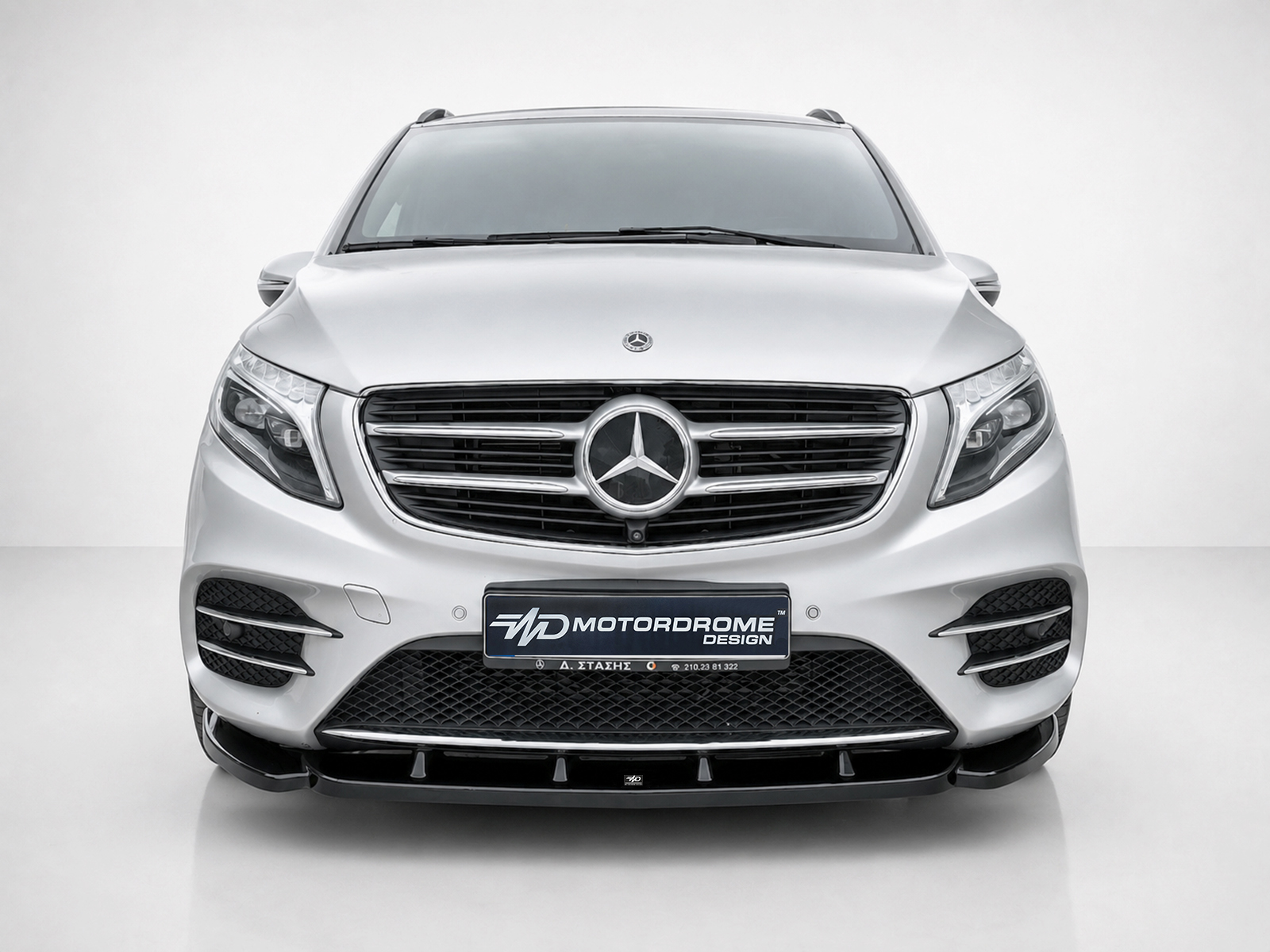 K195-002_1jpg - OPSHOLDERS Front view of a silver Mercedes SUV, prominent grille with emblem, in a studio setting.