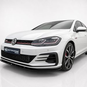 White Volkswagen sedan in a studio setting, shown from the front-right three-quarter angle with a black honeycomb grille and red accents.