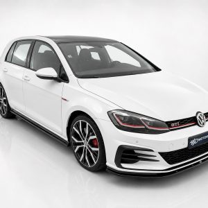 White Volkswagen Golf GTI with red accents and large multi-spoke wheels, photographed in a white studio setting.