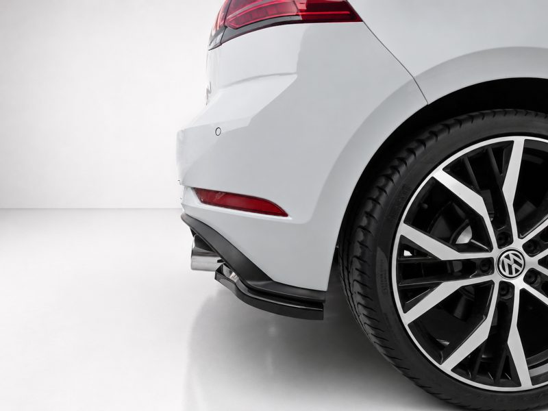 K196-003_4jpg - OPSHOLDERS Rear-right corner of a white car showing the taillight, bumper, and large alloy wheel with a VW logo