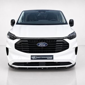 Front view of a white Ford van with a large black grille and Ford emblem, displayed in a studio setting with a 'MOTORODOME DESIGN' plate below the grille.