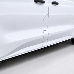 Side view of a white van showing sliding door, door handles, and alloy wheel visible at the back of the vehicle