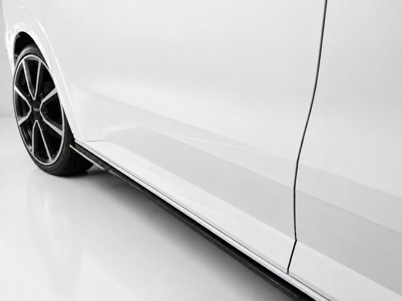 White car side profile focusing on alloy wheel and lower body panel (running board visible).