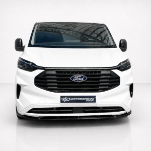 Front view of a white Ford van in a studio, showing black grille and Ford emblem.