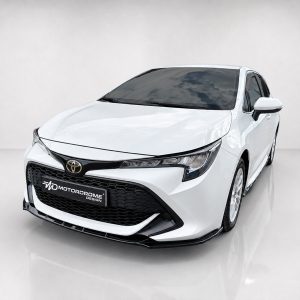 White Toyota sedan shown from a front-left angle in a studio setting, with a glossy black grille and logo visible.