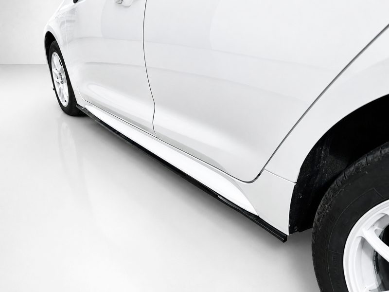 Side view of a white car showing the lower body and running board along the side edge.