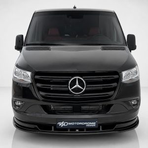 Front view of a black Mercedes-Benz van facing the camera, prominent emblem on grille and sleek headlights in a studio setting