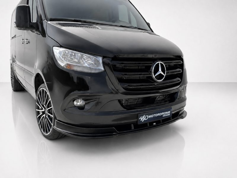 Front-left three-quarter view of a glossy black Mercedes-Benz van with prominent grille and large alloy wheels in a studio setting