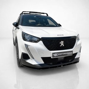 Front-left three-quarter view of a white Peugeot SUV in a studio, featuring a black grille, prominent lion emblem, and roof rack.