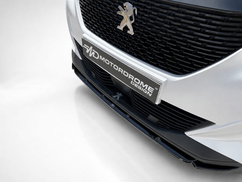 Front view of a silver Peugeot car showing the emblem and a chrome plate reading Motordrome Design on the grille area of the bumper.