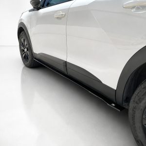 White SUV side view highlighting the black lower side skirt and wheel area, near the door panel.