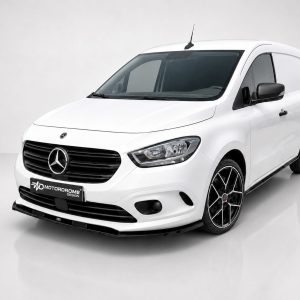 White Mercedes-Benz van with black grille and sporty alloy wheels, shown in a studio setting with a Motordrome Design plate on the front bumper.