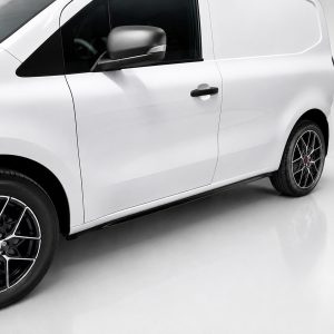 White panel van photographed from the side, featuring black-tinted windows and stylish alloy wheels.