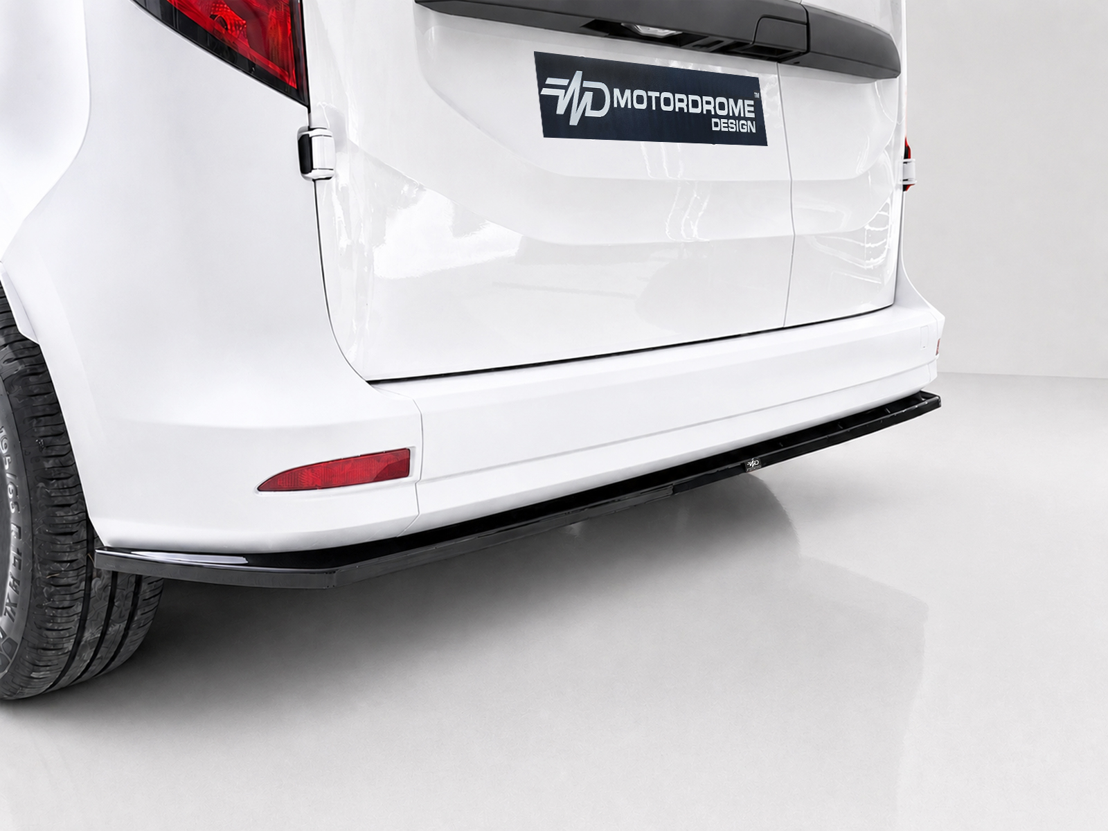 K204-003_2jpg - OPSHOLDERS White SUV rear end with a Motordrome Design badge on the tailgate and a black bumper guard visible under the tailgate.