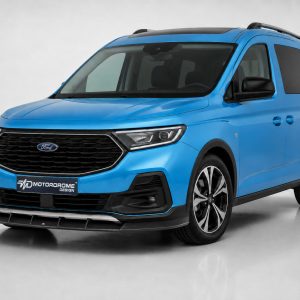 Blue Ford van shown from a three-quarter front view in a studio setting, highlighting the bold grille and headlights.