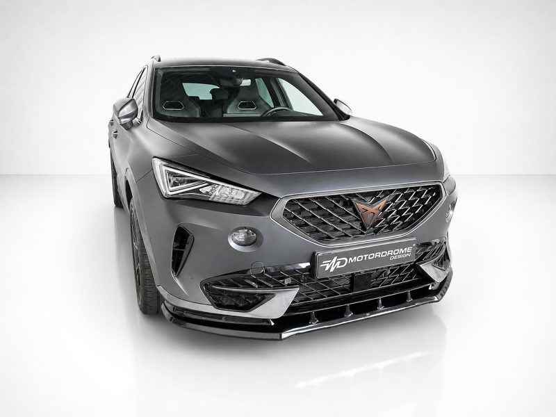 Front three-quarter view of a gray SUV in a white studio, featuring a diamond-pattern grille and Motordrome Design badge