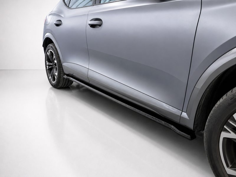 Side view of a gray SUV with a running board and large alloy wheels for a modern look.