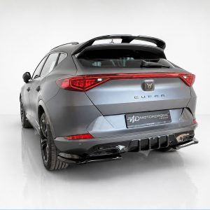 Rear three-quarter view of a metallic gray CUPRA hatchback/SUV with a large rear spoiler in a white studio setting, showing red taillights and badge row.