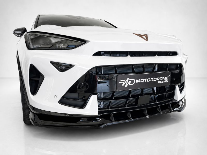 Front view of a white sports car with black grille and Motordrome Design plate in the center.ensuring a concise studio shot context.