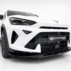 White sports car front view with black grille and emblem, low stance, photographed in a studio.