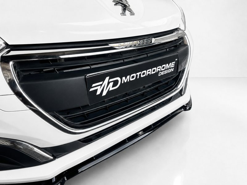 K209-001_4jpg - OPSHOLDERS Close-up of a white car's front grille with chrome accents and a black license plate reading MOTORDROME DESIGN.