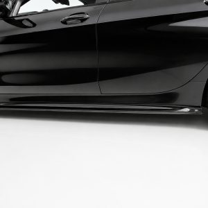 K210-002_2jpg - OPSHOLDERS Close-up of a black car's lower side panel and wheel, showing a glossy finish and side skirt edge far from the ground.