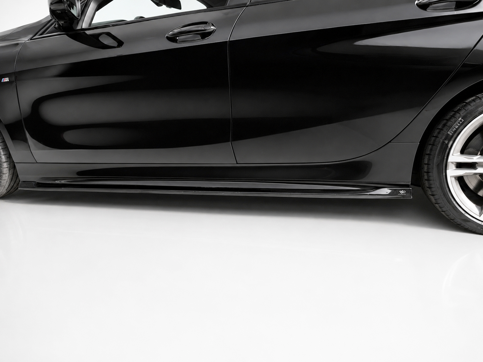 K210-002_2jpg - OPSHOLDERS Close-up of a black car's lower side panel and wheel, showing a glossy finish and side skirt edge far from the ground.