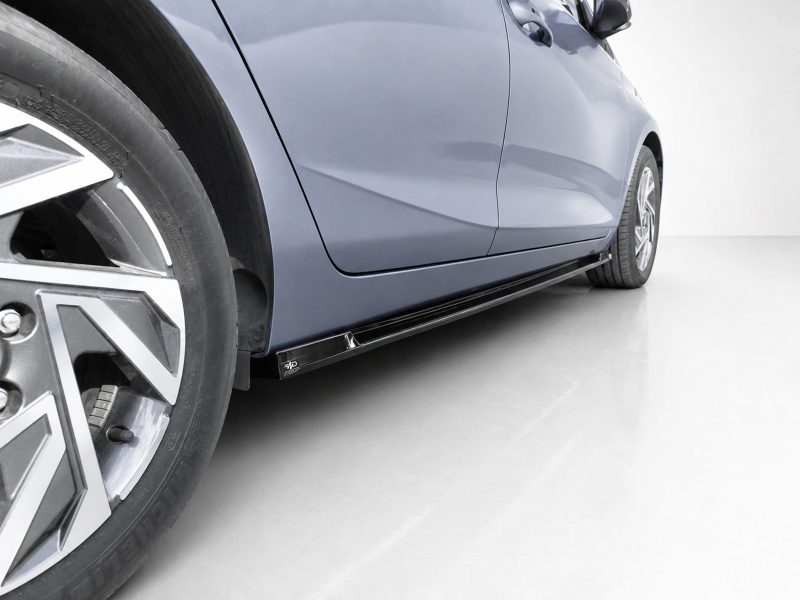 Blue car side view focusing on the front wheel and long black side skirt under the doors
