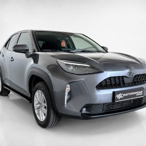 Grey Toyota crossover photographed in a studio, angled front view highlighting the grille and headlights.