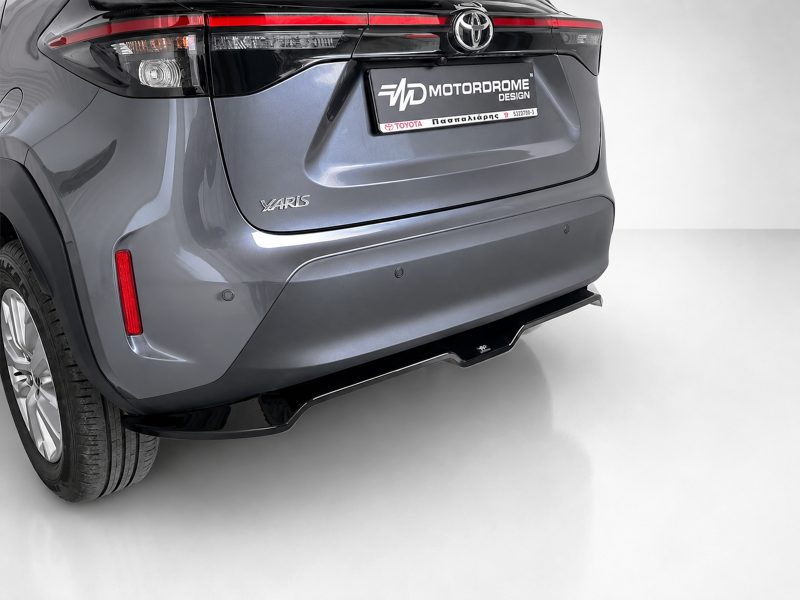 K213-003_4jpg - OPSHOLDERS Rear view of a metallic gray Toyota Yaris featuring the taillights, YARIS badge, and a black MOTORDROME DESIGN dealership plate on the trunk.