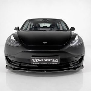 Front view of a black Tesla car in a white studio, with a Motorodrome Design plate on the bumper
