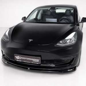 K214-001_3jpg - OPSHOLDERS Front three-quarter view of a black Tesla electric car in a studio setting, showcasing the glossy paint and distinctive headlights.