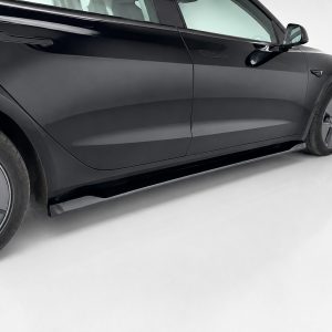 Side view of a sleek black car with flush door handles and large alloy wheel on a light surface