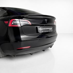 K214-004_3jpg - OPSHOLDERS Rear view of a sleek black sedan in a white studio, showing taillights and a license plate reading 'Motordrome Design' (custom plate).