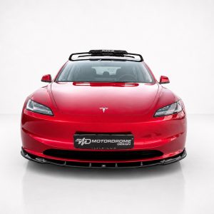 Front view of a red Tesla with a roof rack in a bright white studio setting, logo visible on the hood.