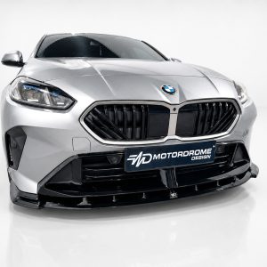 Front view of a silver BMW car in a studio, highlighting the large kidney grille and sculpted bumper.